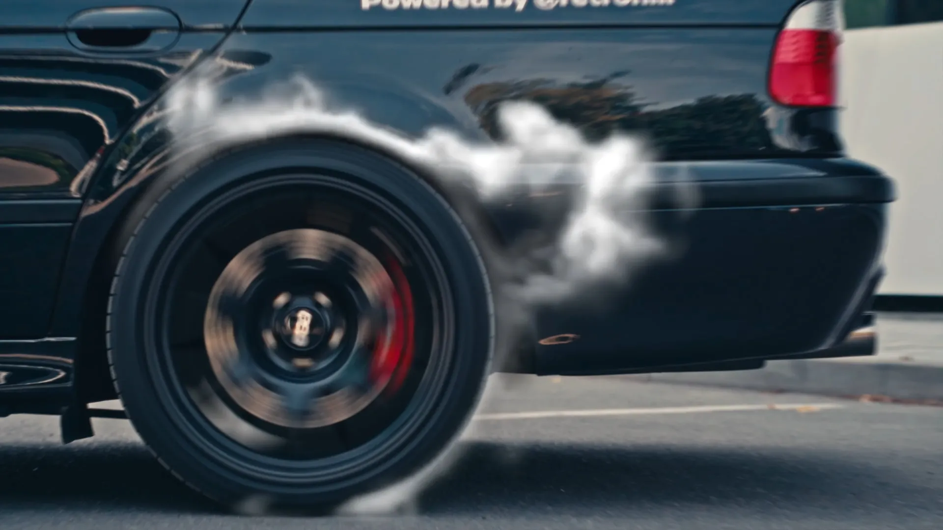 BMW M5 video thumbnail featuring spinning wheel, motion blur, and sports car performance